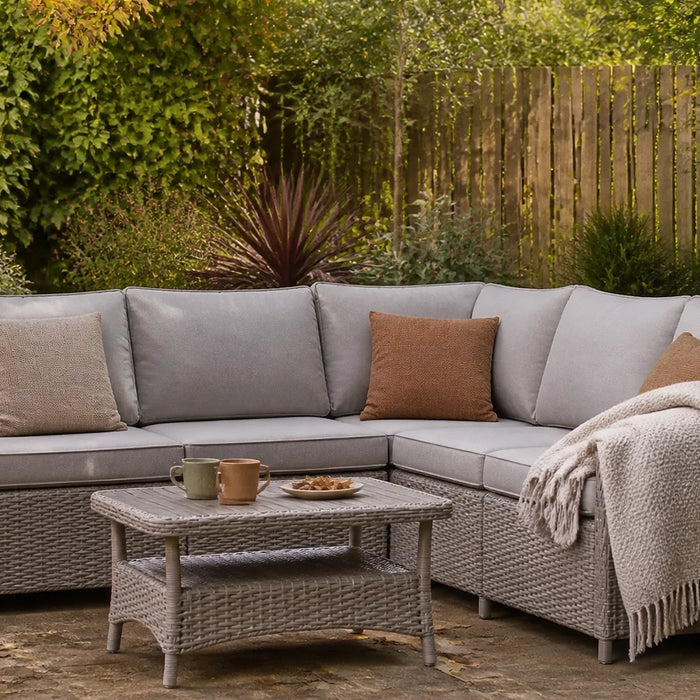 Contemporary garden furniture set in a warm autumn garden with fallen leaves and neutral cushions